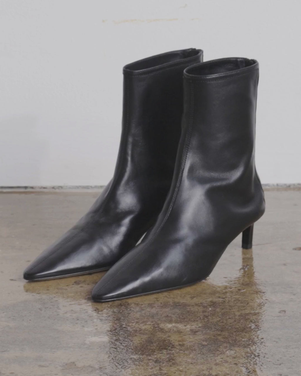 Dear Frances Topo Bootie in black leather, shown as a pair and worn with tailored trousers, showing the pointed toe and kitten heel